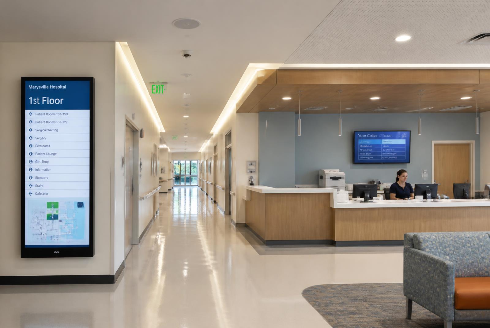 Hospital corridor equipped with ceiling paging speakers and digital signage wayfinding screens, using real-time adaptive sound masking to support Quiet Hospital goals.