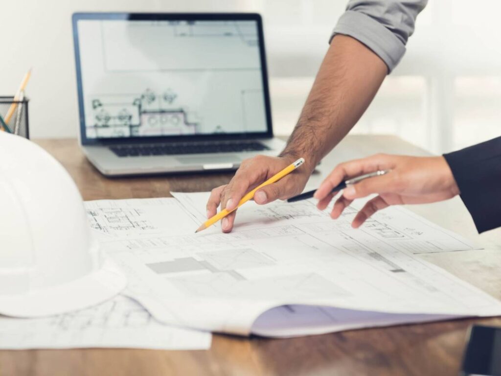 Consultants reviewing audiovisual drawings at a design workstation